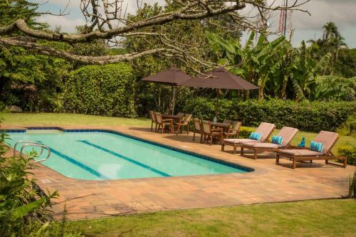 uma piscina com cadeiras e um guarda-sol em Hotel Delirio Campestre em Montenegro