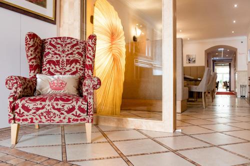 a red chair in a room with a dining room at Hotel Krone in Mondsee