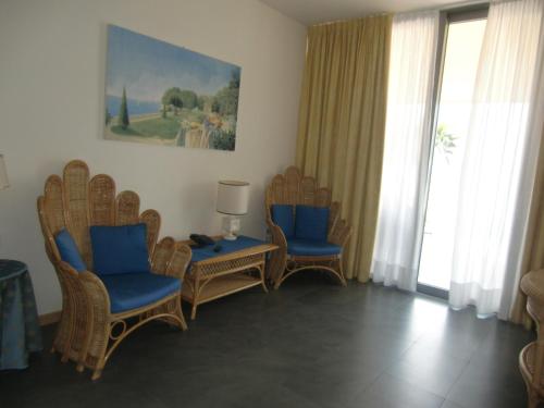a living room with chairs and a table and windows at Beach Hotel Du Lac Malcesine in Malcesine