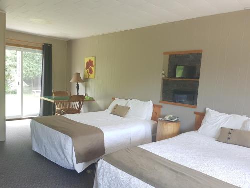 a hotel room with two beds and a window at The Spirit Rock Outpost & Lodge in Wiarton