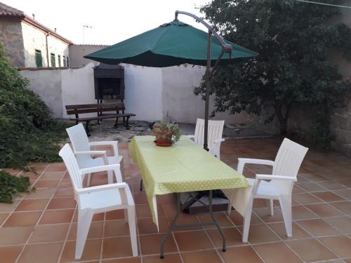 a table and chairs with an umbrella on a patio at Casa Luz in Ávila