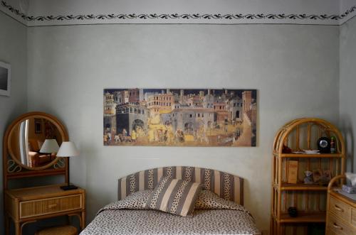 a bedroom with a bed and a painting on the wall at Casa di Luli in Siena
