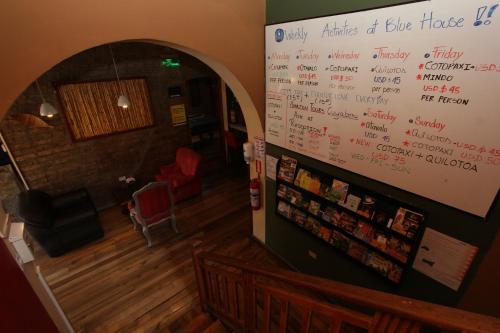 a room with a large white board with writing on the wall at Blue House Youth Hostel in Quito