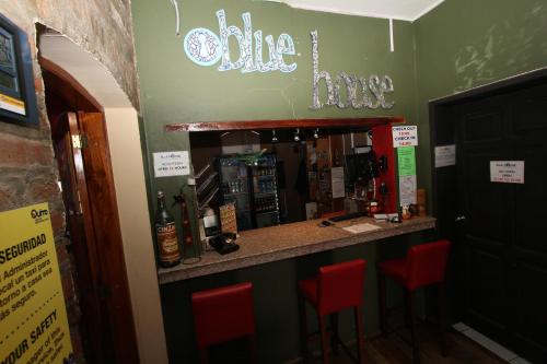 a bar in a restaurant with red stools at Blue House Youth Hostel in Quito