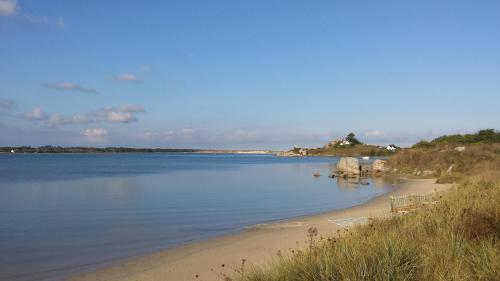 a beach with chairs on the shore of a body of water at Ty Theven in Plouescat