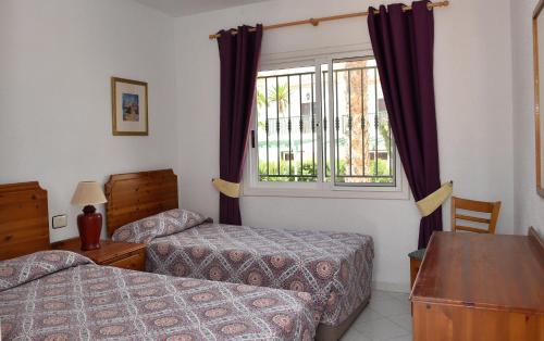 a hotel room with two beds and a window at Las Adelfas 2 in San Miguel de Abona