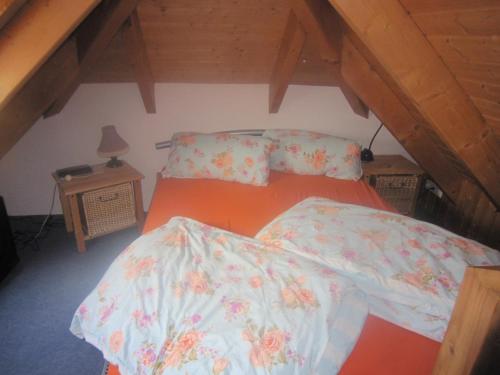 a bedroom with an orange bed with floral sheets at Studio Orchidee in Weißig