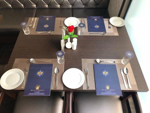 a wooden table with plates and utensils on it at The One Hotel in Aurangabad