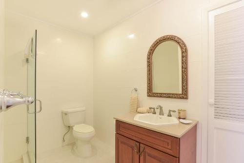 
a bathroom with a sink, toilet, and bathtub at Addison Lee Cayman Villa in George Town
