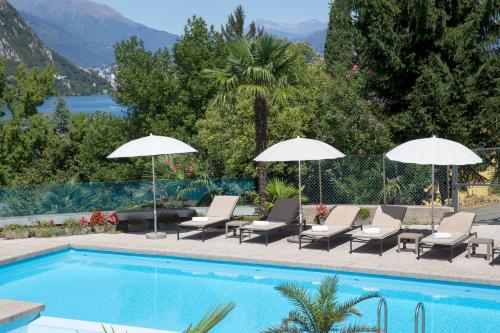 a swimming pool with lounge chairs and umbrellas next to a swimming pool at Hotel Campione in Bissone