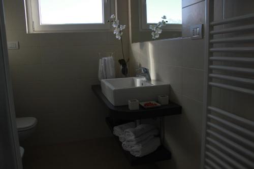 a bathroom with a sink and a toilet and a window at Residence Villa Paradiso in Gravedona