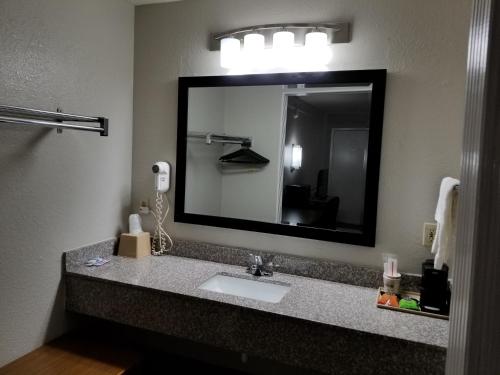 uma casa de banho com um lavatório e um espelho grande em Hill Country Inn em Marble Falls