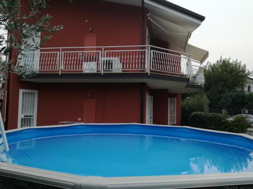 a house with a blue swimming pool in front of a building at Appartamento Villa Tony in Lazise