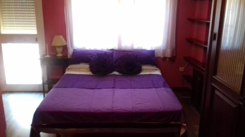 a purple bed in a room with a window at Los Girasoles in Fuengirola