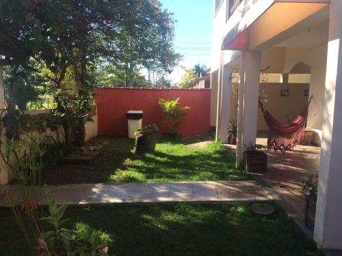 a backyard with a red fence and a hammock at Pousada Recanto do Mar in Saquarema