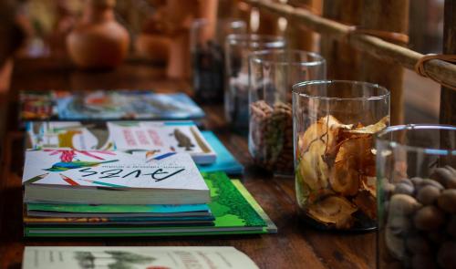 a wooden table with glasses and books on it at Pousada Trijunção in Rodeador