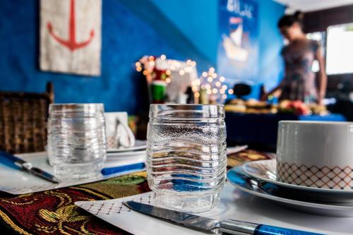 a table with glasses of water and plates on it at Blue Hostel in Natal