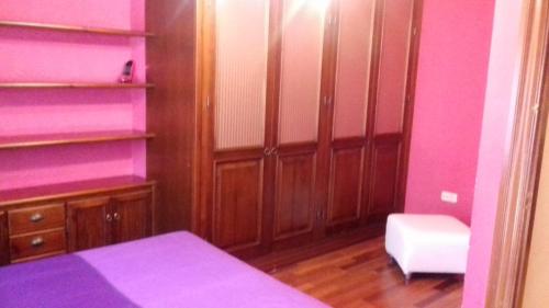 a bedroom with pink walls and wooden shelves at Los Girasoles in Fuengirola