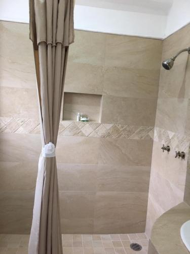 a shower with a shower curtain in a bathroom at Palma Real in Manzanillo