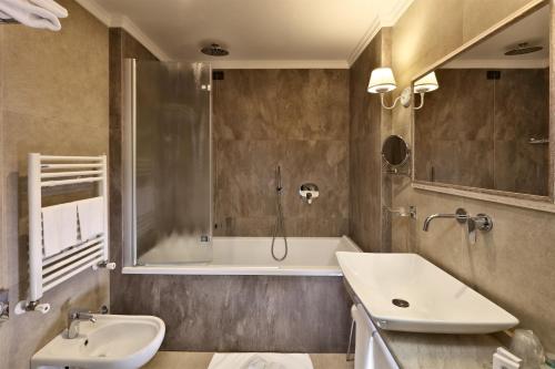 a bathroom with a tub and a sink and a shower at Villa Angela in Taormina
