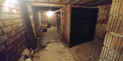 a dark room with a brick wall and a doorway at Ubytování Markéta in Perná