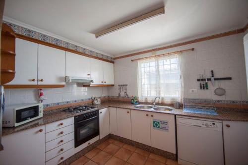 a kitchen with white cabinets and a sink at Casa vacaciones in Castellón de la Plana