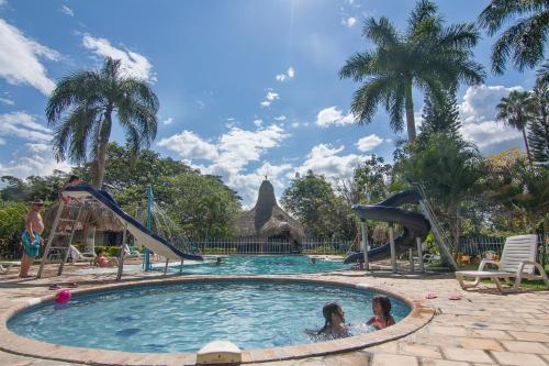 Rozo的住宿－Hotel Campestre el Fuerte，两名儿童在度假村的游泳池玩耍
