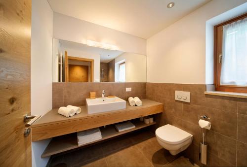 a bathroom with a sink and a toilet and a mirror at Sonnenhof in Rifiano