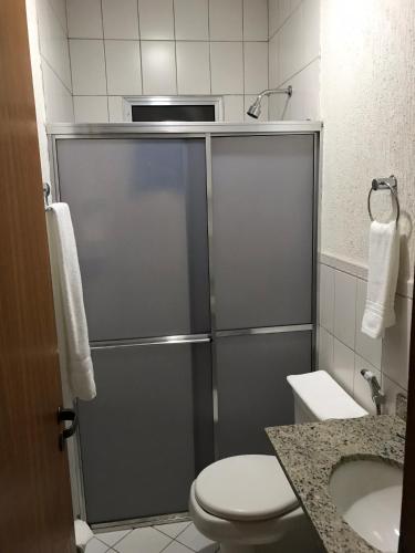 a bathroom with a shower with a toilet and a sink at Bravo City Rondonópolis in Rondonópolis