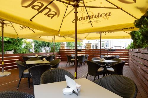 a restaurant with tables and umbrellas on a deck at Hotel Vila Tina in Zagreb