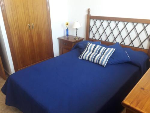 a blue bed with a pillow on top of it at Burrero Seasight in Ingenio