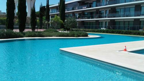 a blue swimming pool in front of a building at Residence Golf Club, Vilamoura in Vilamoura