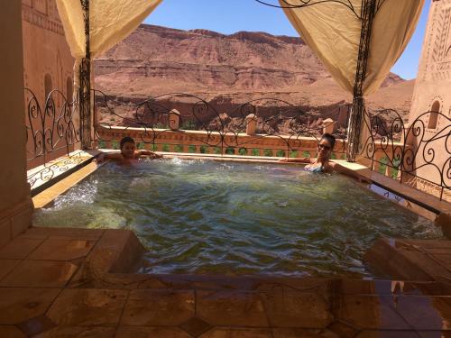 two people in a hot tub with a view of the desert at Kasbah Titrit & Spa in Aït Ben Haddou