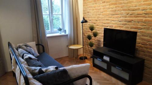 a living room with a couch and a tv at Apartment Úvoz Street 64 in Brno