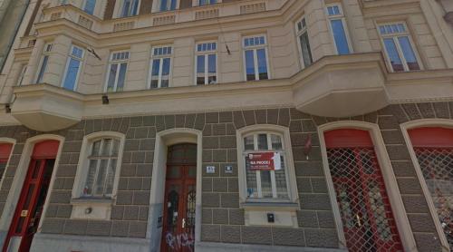 een groot bakstenen gebouw met rode deuren en ramen bij Apartment Úvoz Street 64 in Brno