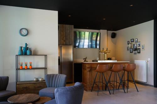 a kitchen with a counter and a bar with stools at B&B Ten Doele in Middelkerke