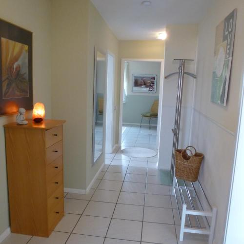 a hallway with a dresser and a chair in a room at Ferienwohnung Wölfle in Friesenheim