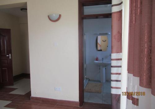 a bathroom with a sink and a mirror at Lakeview LUX Apartment in Kisumu