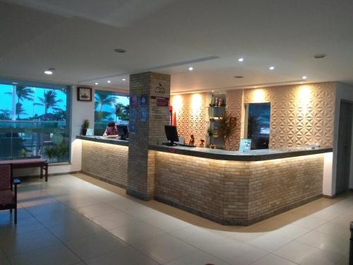 a restaurant with a bar in a building at Simas Praia Hotel in Aracaju