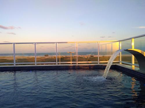 a pool with a fountain in the middle of a building at Simas Praia Hotel in Aracaju