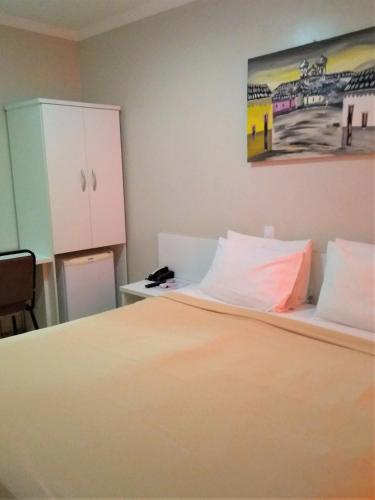 a bedroom with a bed and a painting on the wall at Simas Praia Hotel in Aracaju