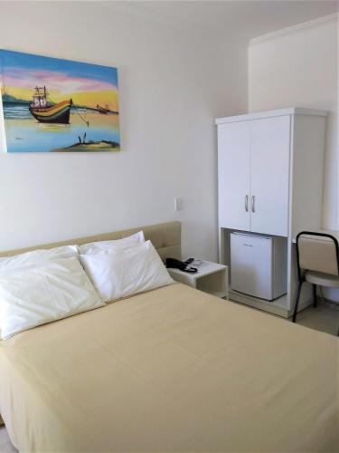 a bedroom with a bed and a white cabinet at Simas Praia Hotel in Aracaju
