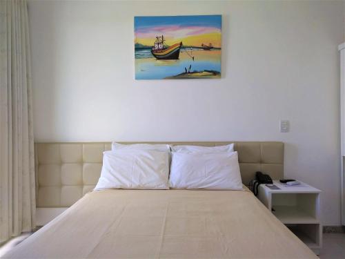 a bedroom with a bed with a painting on the wall at Simas Praia Hotel in Aracaju