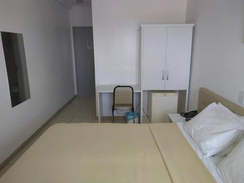 a bedroom with a bed and a chair in it at Simas Praia Hotel in Aracaju