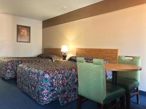 a hotel room with a bed and a table and chairs at American Motel in Wheat Ridge