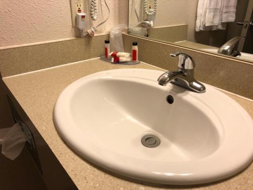 a white sink in a bathroom with a mirror at Howard Johnson by Wyndham Salem in Salem