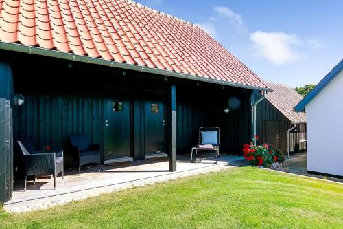 a green house with two chairs and a roof at Troense Bed and Breakfast by the sea in Svendborg