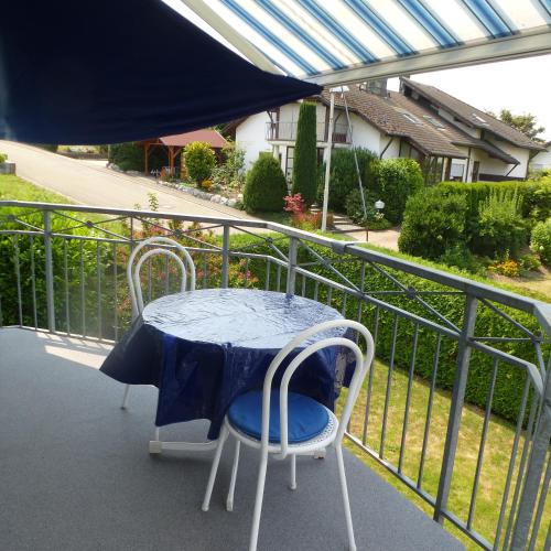 a table and two chairs on a balcony at Ferienwohnung Wölfle in Friesenheim