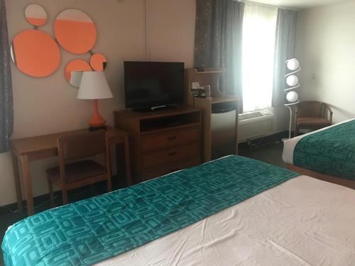 a hotel room with a bed and a television at Howard Johnson by Wyndham Salem in Salem