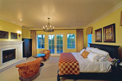 a large bedroom with a bed and a fireplace at The Villa at Arden Hills in Sacramento